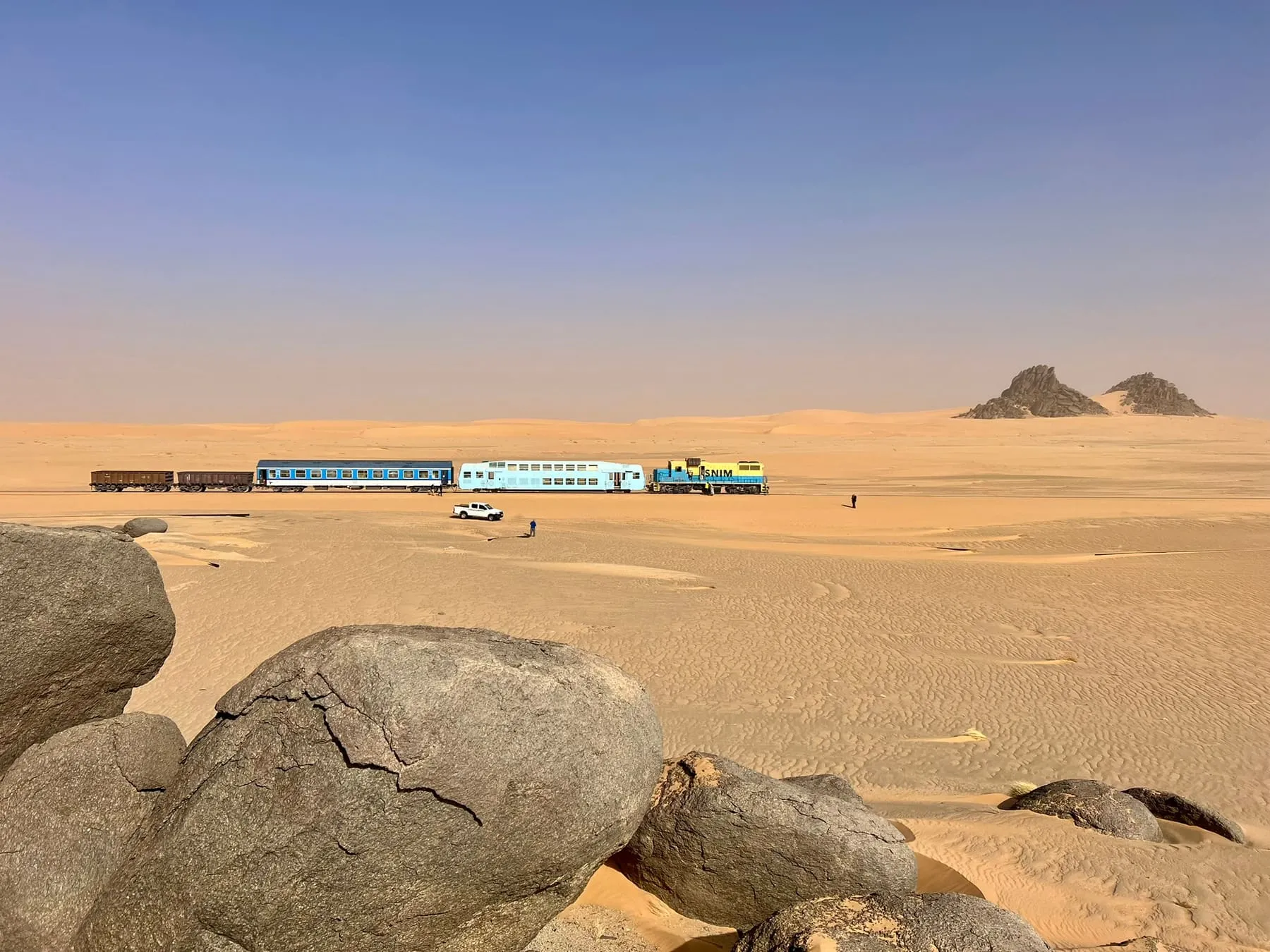 Der Train du Désert in der mauretanischen Sahara, im Vordergrund große Felsbrocken